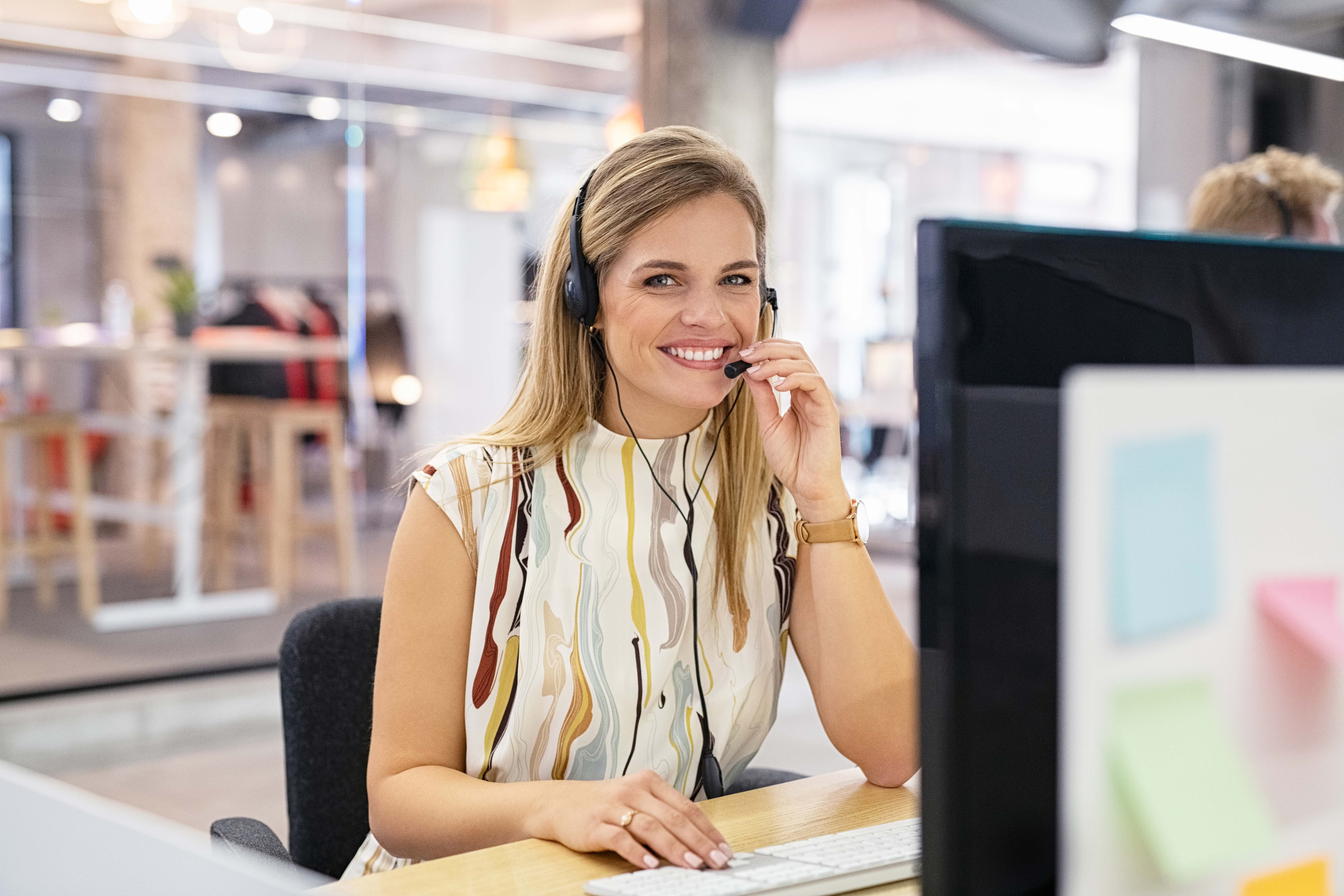 Smiling call center operator at desk